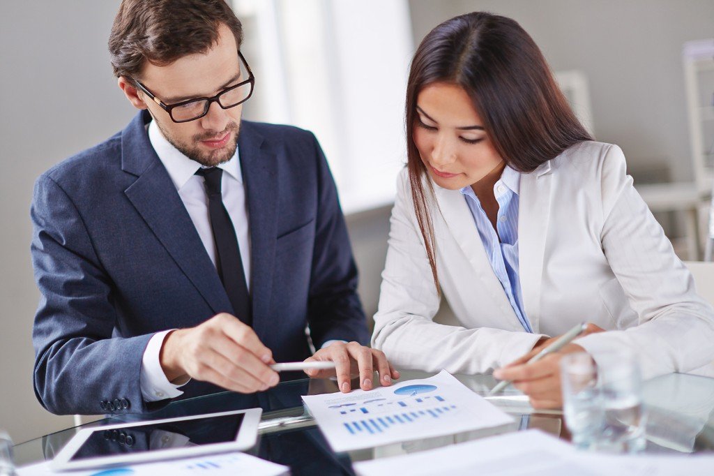 Asesores revisando gráficos tributarios en una reunión formal